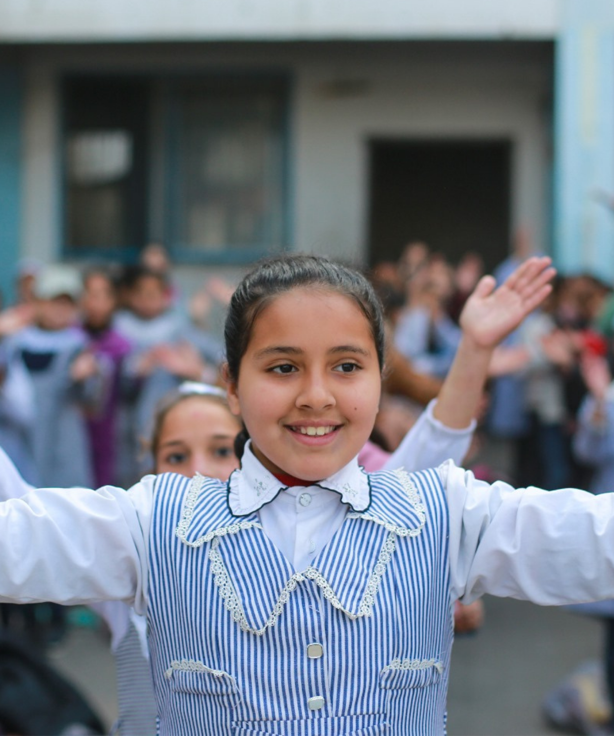A young Palestine Refugee child stands in the school morning assembly, embodying hope, resilience, and the right to education.